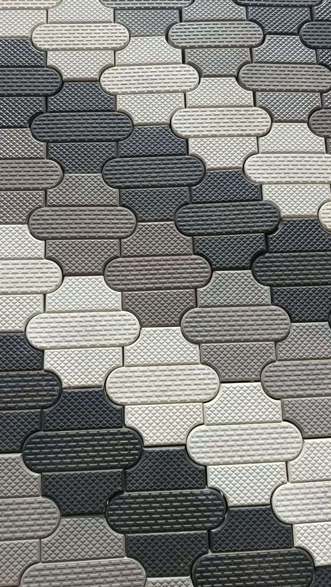 Oval soft-grip cabro in grey, white and charcoal with a textured non-slip face, close-up of the woven interlock pattern