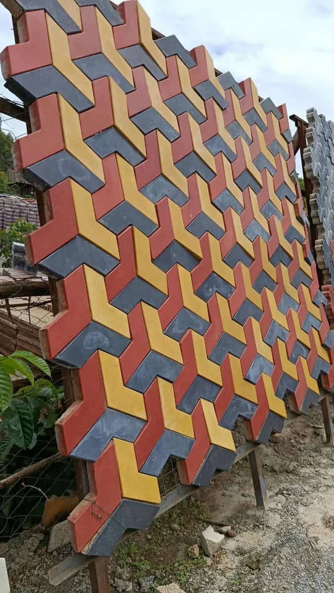 3D hexagon cabro in red, yellow and charcoal with the cube illusion, on a display stand in the yard
