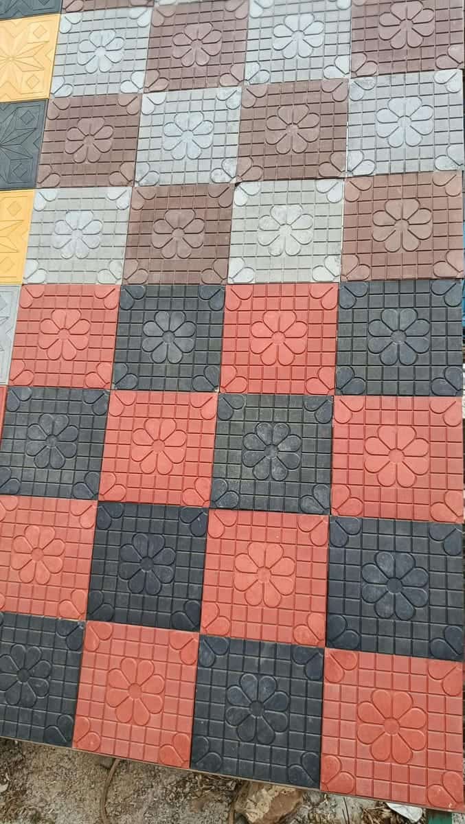 Square sunflower-embossed cabro in red, charcoal and grey checkerboard on a yard display panel