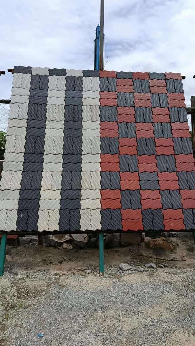 Unipaver zigzag cabro sample panel with grey, charcoal and red blocks laid in stripes and a checker pattern, on display in the yard