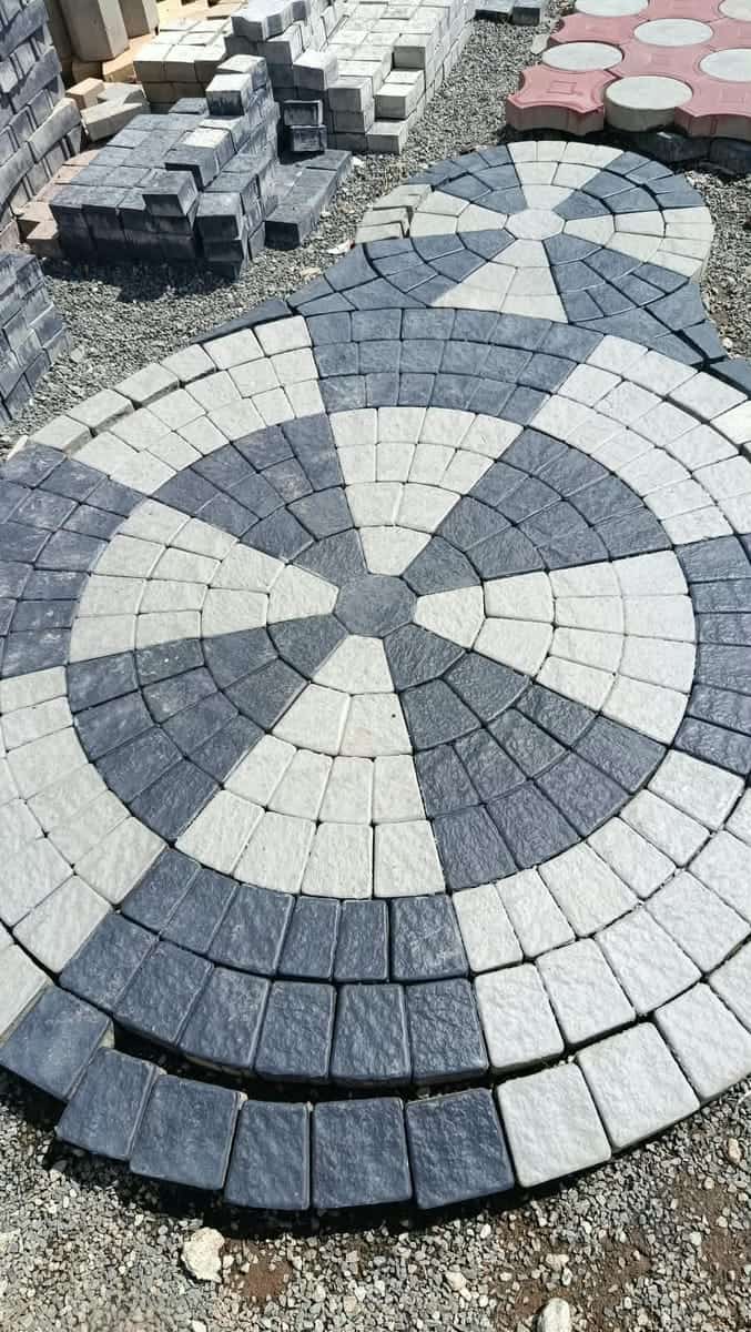 Grey and charcoal cobble-style circle kit cabro laid as a full circle in the yard