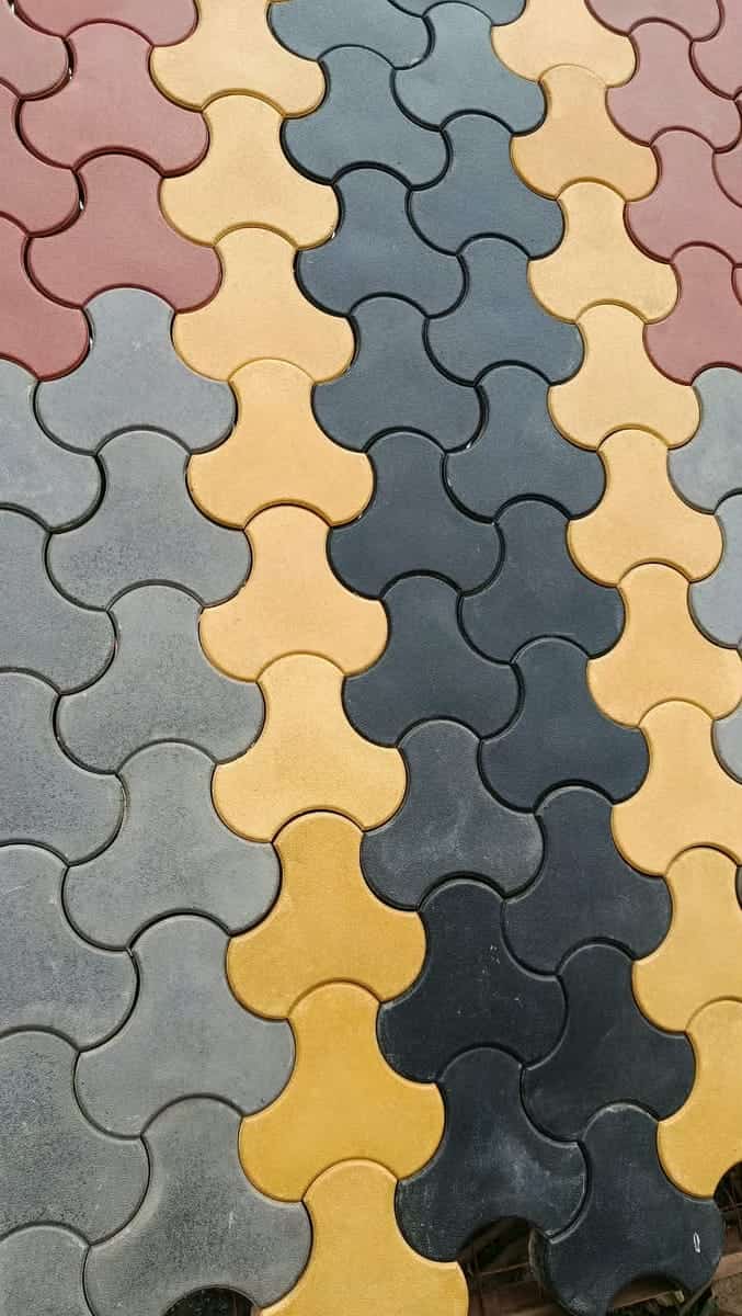 Close-up of yellow, charcoal, red and grey dumbbell cabro showing the bone-shaped interlock