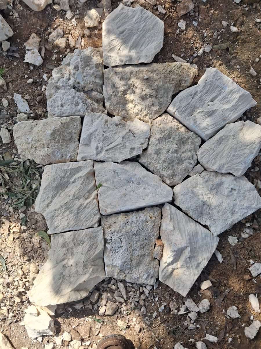 Mazeras stone in random crazy-paving pieces laid out on the ground, grey and cream tones with a rough split face